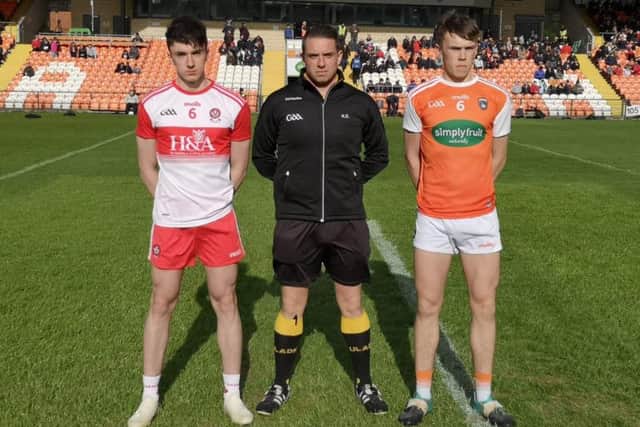 Derry Minor captain Aidan McCloskey and Armagh captain Sean McVerry line out alongside match referee Kieran Eannetta in the Athletic Grounds on Saturday.