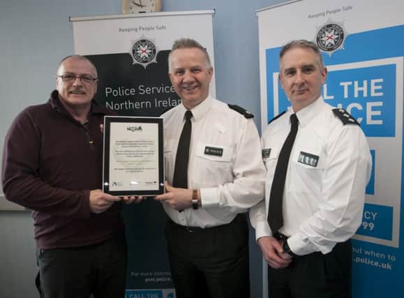 Robin Young, Foyle Racial Equality Forum and member of the â¬ÜWe All Belongâ¬" campaign pictured presenting Chief Inspector Jonathan Hunter and Chief Inspector Alan Hutton with the A4 size framed pledges at Strand Road PSNI Station last week.