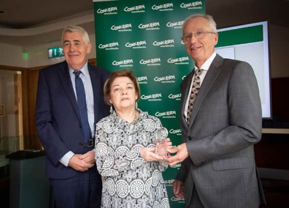 Frances Robson of Concerns Derry Support Group receives an award on behalf of the group from Concern CEO Dominic MacSorley and Chairman John Treacy.