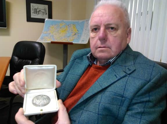 Robbie McCarter pictured with Dr Pereira's Papal medal from the Pope.