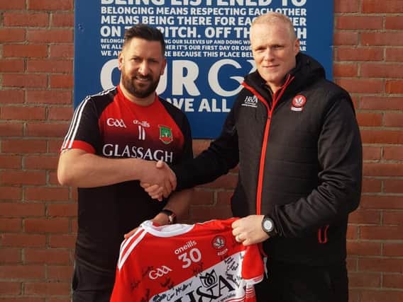 Derry senior manager Damian McErlain presents a signed Derry jersey to Sean Dolan's Games Promotion Officer, Brian O'Donnell when the Oak Leaf county team visited Creggan last week.