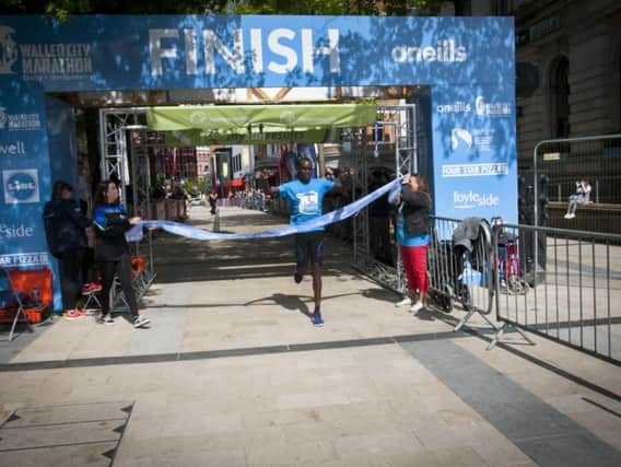 Eric Koech crosses the finish line to win the 2019 Walled City Marathon on Sunday.