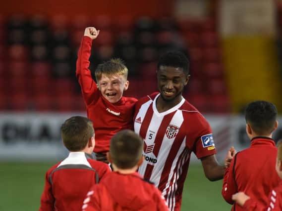 Junior Ogedi Uzokwe celebrates with a young fan at full time