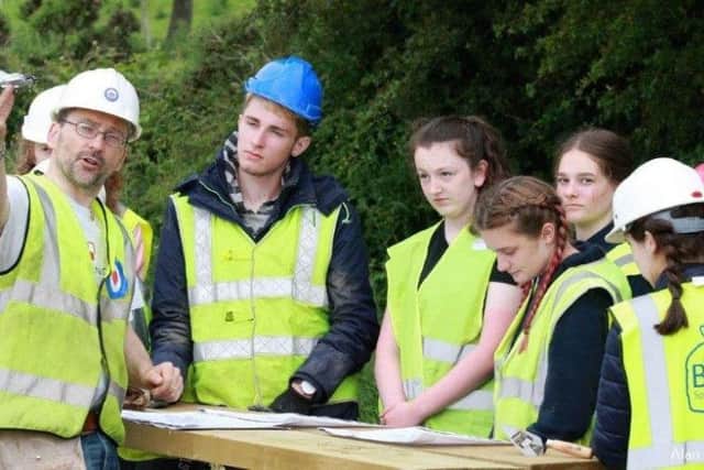 Jonny explains the descent of the plane at the crash site to the young people involved in the dig.