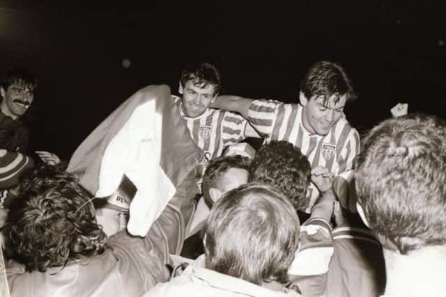 Felix Healy, Kevin Brady and Jack Kaey celebrate with the travelling support after Derry City defeated Dundalk 4-0 to win their first ever League Cup final against Dundalk at Oriel Park in October 13th, 1988.