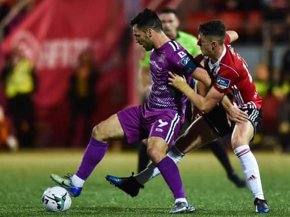 Dundalk's Pat Hoban shields the ball from Derry City defender Eoin Toal.
