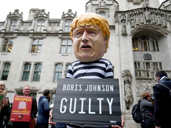 A man wearing a giant Boris Johnson mask, dressed as a prisoner, outside the Supreme Court in London, where judges have ruled that Prime Minister Boris Johnson's advice to the Queen to suspend Parliament for five weeks was unlawful. (Photo: Jonathan Brady/P.A. Wire)