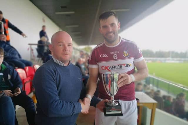 Banagher captain Mark Lynch receives the Derry Intermediate Hurling Championship trophy after victory over Swatragh in Owenbeg.