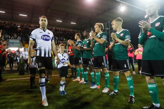 Derry City players and officials form a guard of honour, as skipper Brian Gartland leads champions Dundalk out before Friday night's game.