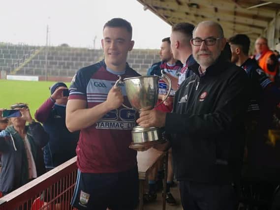 Glack captain Niall McGowan receives The Joe Brolly Memorial Cup from Derry County Chairman, Brian Smith at Celtic Park on Saturday.