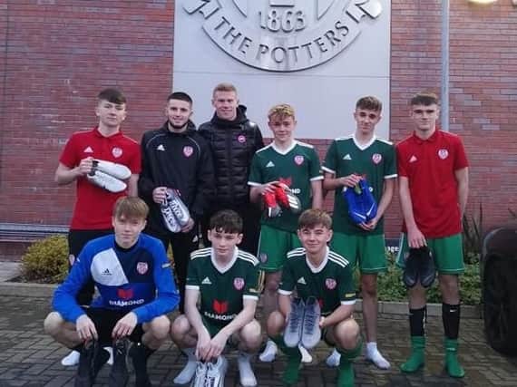 Republic of Ireland winger James McClean pictured presenting football boots to Derry City U15 squad.