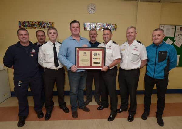 Crew Commander Sam Donnell receives a memento from Area Commander Mark Smyth, at Cresent Link Fire Station recently, to mark his retired from the NIFRS after 30 years service.  Included in the photograph from left are, Firefighter Peter Lynch, Station Commander Peter Melarkey, Station Commander Clive Lowry, Watch Commander Peter Ward, Group Commander Jonathan Tate and Crew Commander Allister Laird. DER4419GS - 070