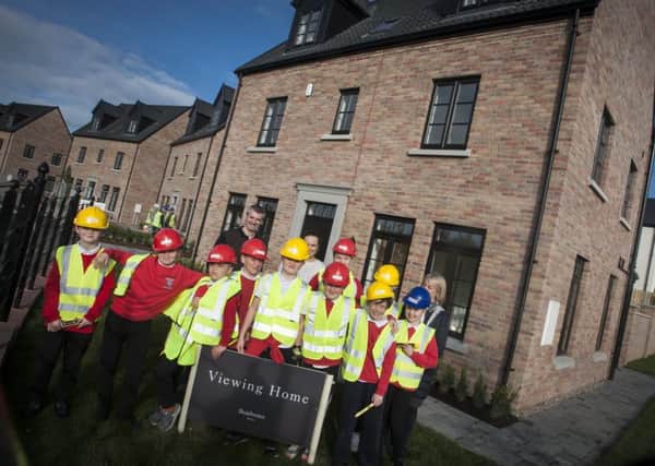 Braidwater representatives with children from Drumahoe P.S. at one of the local firm's other housing developments in the city.