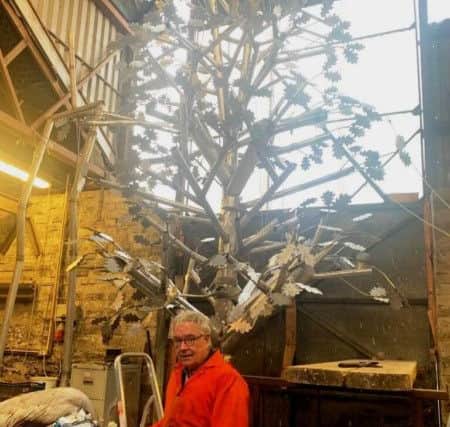 Artist Maurice Harron puts the finishing touches to the new peace tree.
