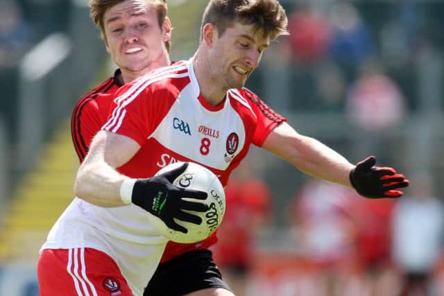 Derry's Niall Holly goes past Down's Caolan Mooney.( Photo Lorcan Doherty / Presseye.com)