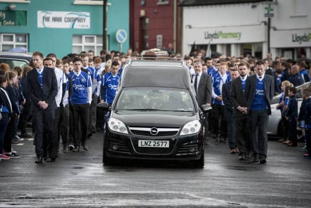 A sea of blue shirts flank the coffin and stand 'guard of honour' as the remains of Conall Kerrigan make their way into the grounds of St. Patrick's Church, Claudy yesterday morning for Requiem Mass. DER3415MC004