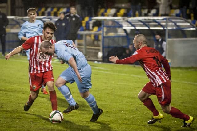 Institute's Declan McKeever attempts to keep possession as two Warrenpoint players close in during Wednesday night's League Cup clash at Drumahoe. DER4615MC038