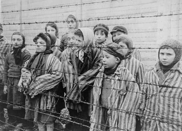 Children at the barbed wire at Auschwitz.