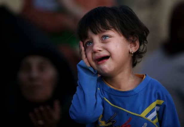 A fleeing Iraqi girl cries after settling with her family near a Kurdish checkpoint, in the Khazer area between the Iraqi city of Mosul and the Kurdish city of Irbil, northern Iraq back in the summer of 2014.  (AP Photo/Hussein Malla)