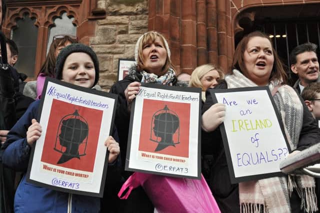 Teachers and supporters carry placards at the protest on the Guildhall steps Derry. DER0416GS025