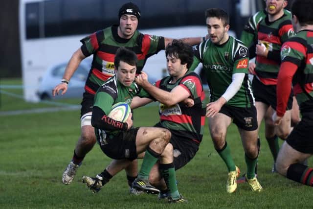 City of Derry's Simon Logue holds off this tackle from Highfield player Chris Bannon as he powers through to score Derry's opening try. INLS0316-147KM