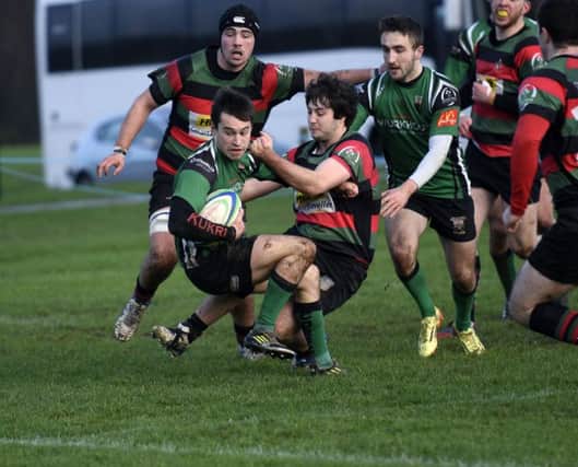 City of Derry's Simon Logue holds off this tackle from Highfield player Chris Bannon as he powers through to score Derry's opening try. INLS0316-147KM