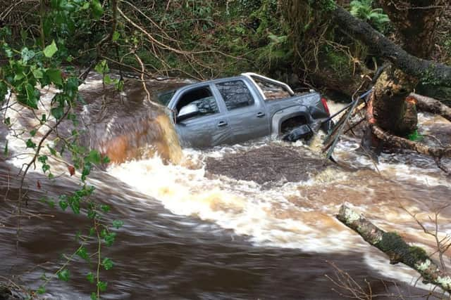 The man's vehicle wedged in a tree. It was subsequently washed away.