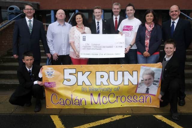 Kim Boyce, mother of the late Caolan McCrossan pictured on Friday handing over a cheque for Â£18,119.86 to Gareth McElduff, Clic Sargent on behalf of the McCrossan Family and St. Columb's College and in memory of St. Columb's student Caolan. The proceeds were raised by a Sponsored 5k Sainsburys Run last month. Included in photo are Mr. Brian Keys, Vice Principal, Mr. Sean McCrossan, Caolan's dad, Eoin McCrossan, Caolan's brother, Mr. Finbar Madden, Principal, Ms. Michaela Doherty, run organiser/teacher and Mr. Thomas Bradley, Vice Principal. At front are students Rian Norrby and Ethan Doherty. DER2515MC070