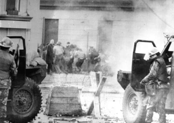 Soldiers taking cover behind their sandbagged armoured cars while dispersing demonstrators with CS gas during protests in Derry on Bloody Sunday.