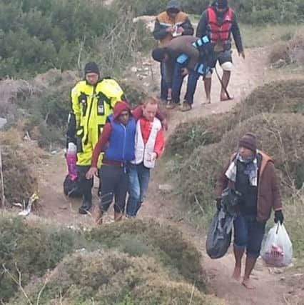 A man in a life-jacket is supported off the boats and on to dry land at Lesvos, Greece (pic: Hilda Orr).