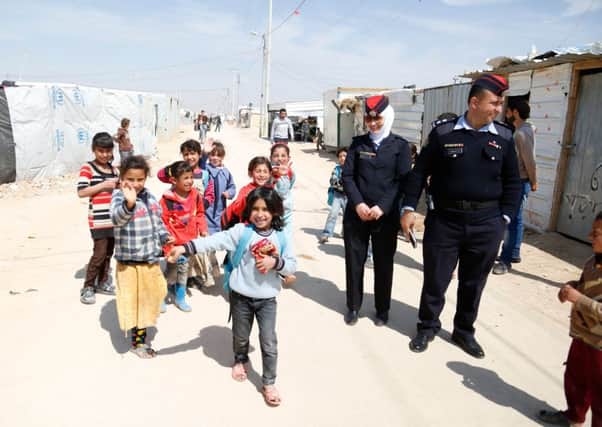 2nd Lieutenant Abeer Al-Masa'ed and Lieutenant Ahmad Mjalli of the Jordanian community police team in the Zaatari refugee camp with some of the younger of the 80,000 Syrian refugees in the camp.