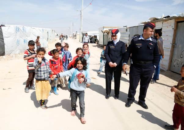 2nd Lieutenant Abeer Al-Masa'ed and Lieutenant Ahmad Mjalli of the Jordanian community police team in the Zaatari refugee camp with some of the younger of the  80,000 Syrian refugees in the camp.