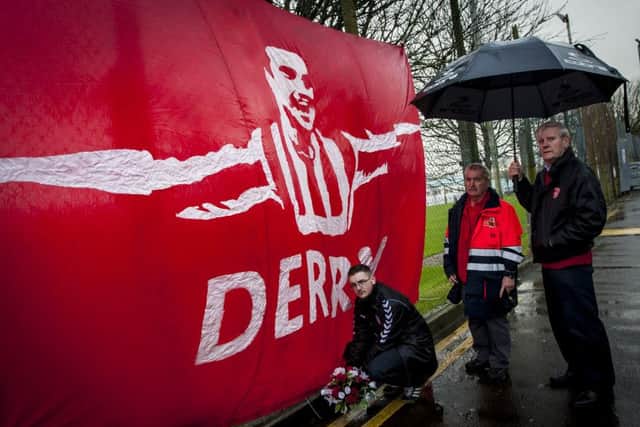 Barry Davey, Jungleside Boys, Derry City Supporters Club pictured laying flowers at the Mark Farren flag flying in the Brandywell on Wednesday afternoon. Included in photo are Martin Dunn and Mickey McBride. The late Derry striker passed away early on Wednesday morning. DER0516MC037