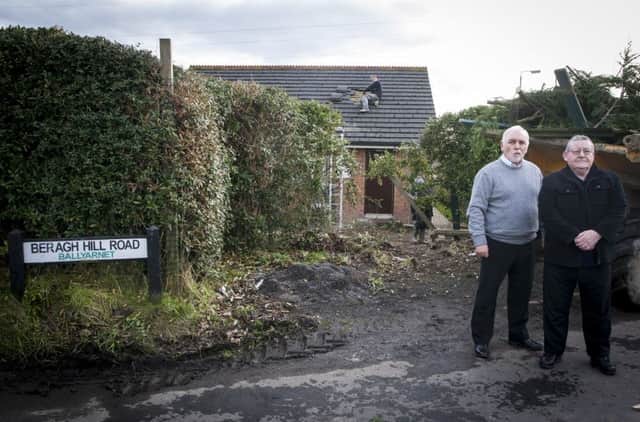 Dr. Charlie McGuigan, son of the elderly owner, pictured with Councillor Tony Hasson surveying the damage to the pensioner's bungalow at Oakgrove Cottages, Ballyarnett after a car crashed into the back of the house early on Sunday morning. DER0716MC002