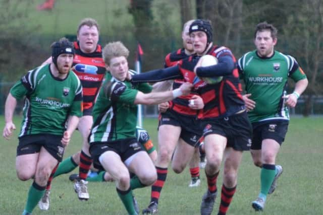 Armaghs Peter Elliot tries to hold off City of Derry scrum half Andrew Semple at the Palace Grounds on Saturday.