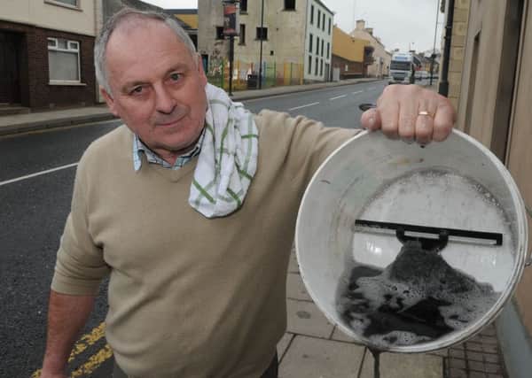Vincent Gallagher from Main Street in Dungiven with the soot filled water which he has cleaned from his windows.INLV711 451MMCK (file pic)