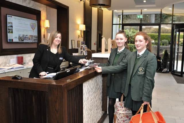 St Cecilias College students Sarah Archer and Chloe Ball check in on their arrival at the Everglades Hotel with Leanne Moore at the hotels reception. The students were among a group from the school on a work experience visit that included an overnight stay on Thursday last. DER0816GS037