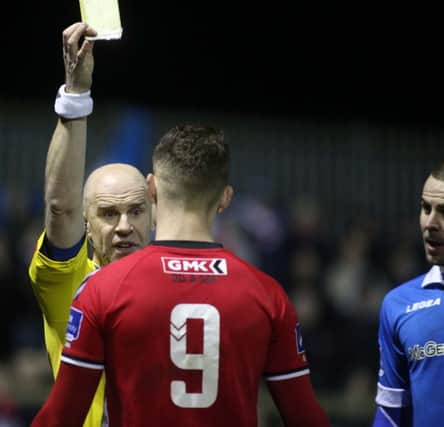Match referee Tomas Connolly books Derry's Jordan Allan and Finn Harps Damien McNulty.