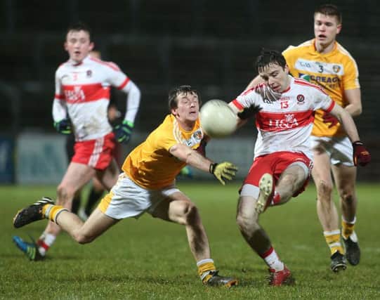 Derry's Niall Toner gets a shot away under pressure from Antrim's Ronan Delargy at Celtic Park on Wednesday night.

(Photo Lorcan Doherty / Presseye.com)
