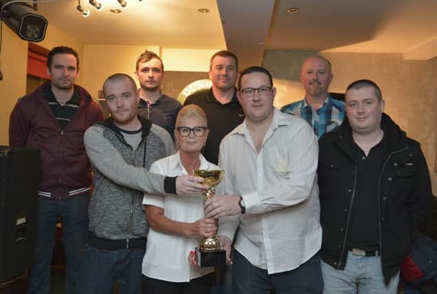 Paula Doherty presents the Friday Nights Dart League Traceys Bar Cup to the winning Maileys Bar team after the recent final. DER0916GS049
