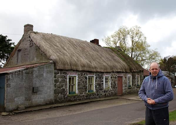 Mark Canning with the cottage at Magilligan.