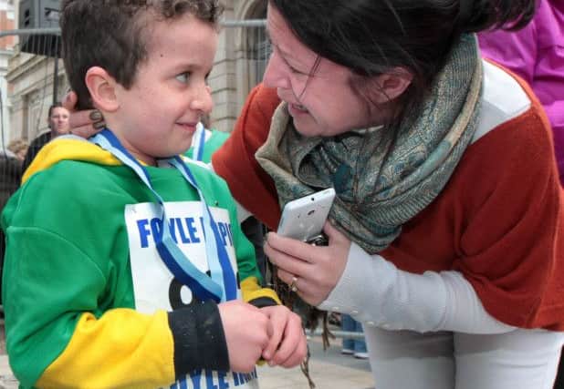 Hugs and kisses from a proud mummy Louise  last year as Evan McGrotty collects his medal for the Walled City Marathon mini race. Picture Margaret McLaughlin
