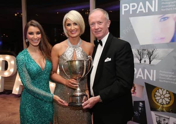 Award winning photographer Audrey Kelly (centre) with one of her awards.