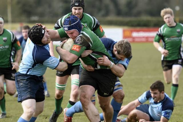 City of Derry's Corey Logan battles to hold off these Barnhall tackles. DER1416-102KM