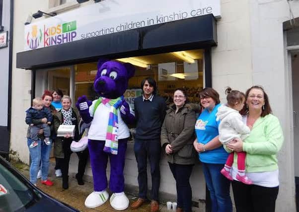 Staff and volunteers pictured with Kuddles the Kinship Bear outside the charity's shop on Spencer Road.