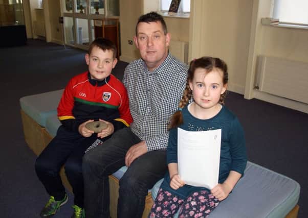 Michael, Charles and Aoife Doherty pictured with the hammer found in Bridgend.