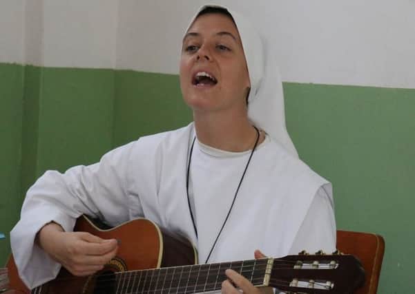 Sister Clare playing her guitar.
