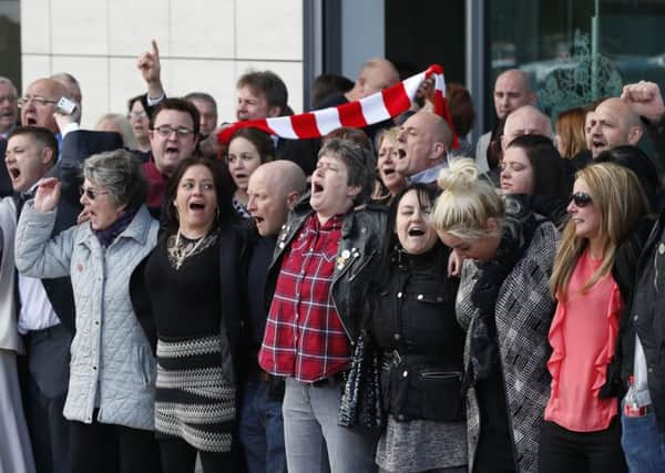 Relatives of those who died in the Hillsborough disaster sing You'll Never Walk Alone on Tuesday outside the Hillsborough inquests in Warrington, where the inquest jury concluded that the 96 Liverpool fans who died were unlawfully killed. (Joe Giddens/PA Wire)