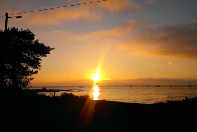 The sunrise over Lough Foyle and County Derry in the distance from Quigley's Point, Inishowen, County Donegal.