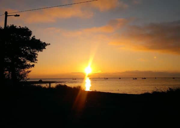 The sunrise over Lough Foyle and County Derry in the distance from Quigley's Point, Inishowen, County Donegal.
